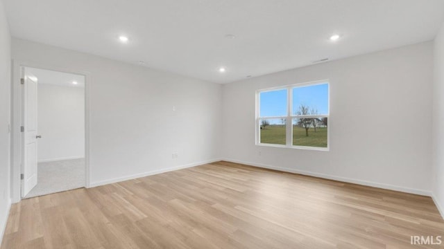 empty room featuring light wood-style floors, recessed lighting, and baseboards