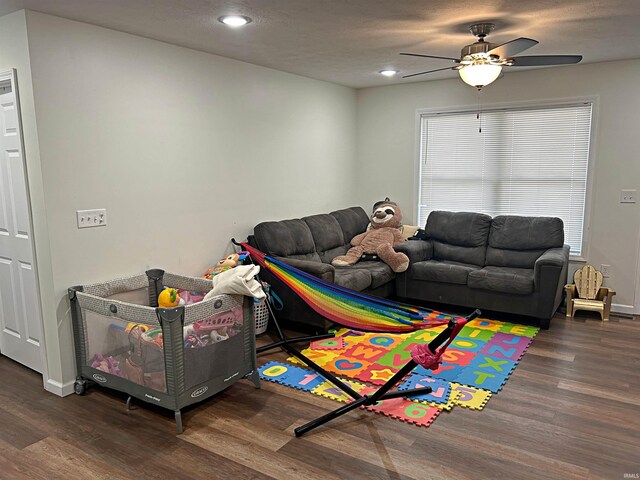 game room with ceiling fan and dark wood-type flooring