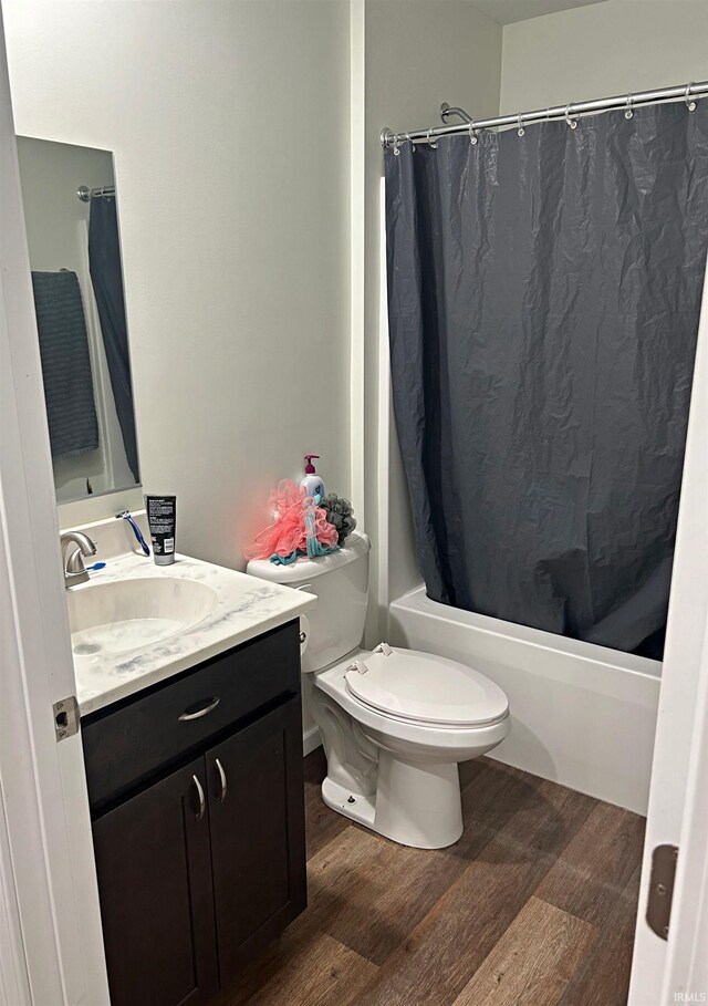 full bathroom with shower / bathtub combination with curtain, vanity, toilet, and hardwood / wood-style floors