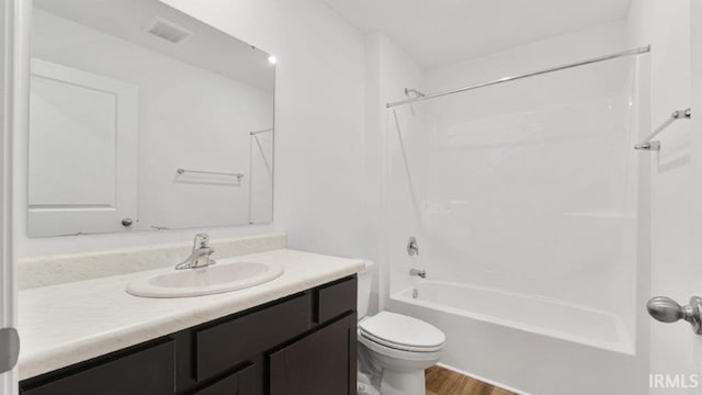 full bathroom with bathing tub / shower combination, hardwood / wood-style floors, vanity, and toilet