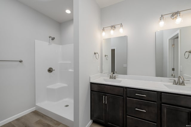 bathroom featuring a shower, hardwood / wood-style floors, and vanity