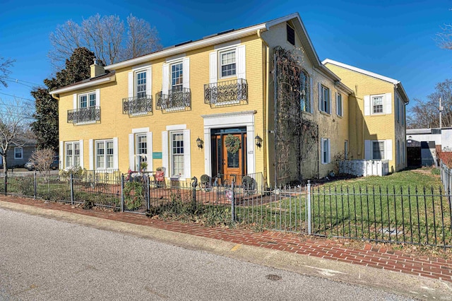 colonial inspired home featuring a front lawn