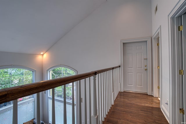 hallway with dark hardwood / wood-style floors and lofted ceiling