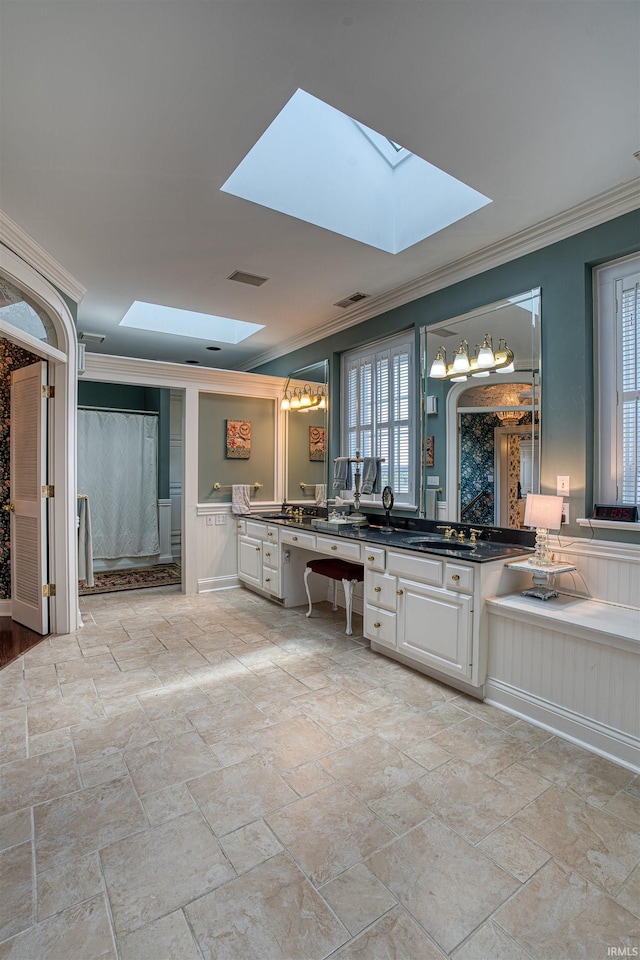 bathroom with vanity, crown molding, and a skylight