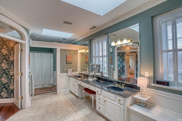 bathroom with vanity, a skylight, walk in shower, and ornamental molding