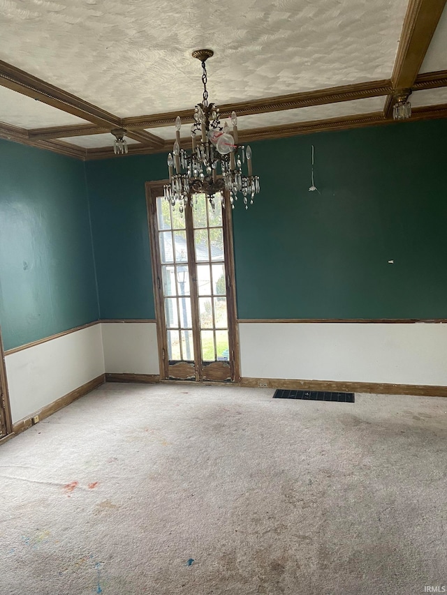 empty room featuring carpet flooring, beamed ceiling, and a chandelier