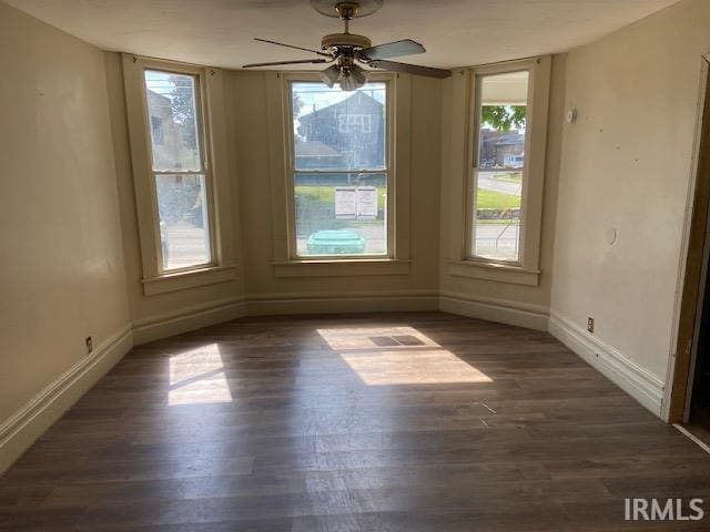 unfurnished dining area with ceiling fan and dark hardwood / wood-style floors