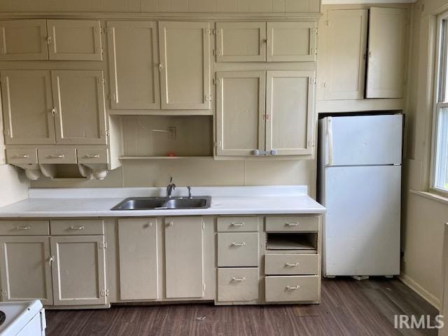 kitchen with white refrigerator, dark hardwood / wood-style flooring, stove, and sink