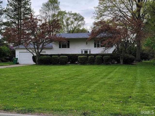 view of front of home with a front lawn and a garage