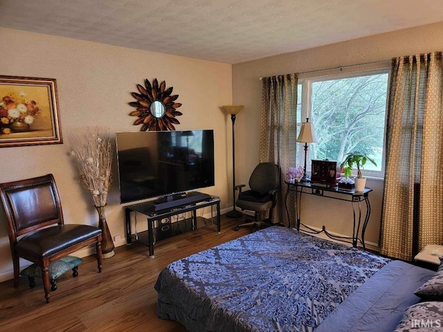 bedroom with a textured ceiling and hardwood / wood-style flooring