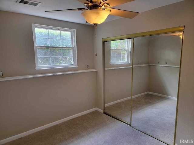 unfurnished bedroom with carpet flooring, ceiling fan, and a closet