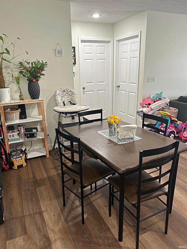 dining area with a textured ceiling and hardwood / wood-style flooring