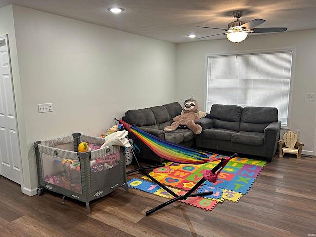 rec room featuring ceiling fan and dark wood-type flooring