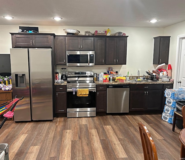 kitchen with dark hardwood / wood-style flooring, dark brown cabinetry, sink, and appliances with stainless steel finishes