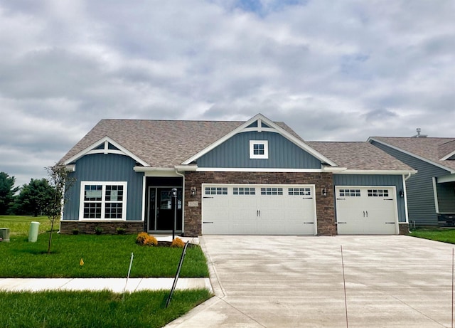 craftsman house featuring a front yard and a garage