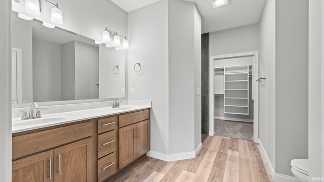 bathroom with wood-type flooring, vanity, and toilet