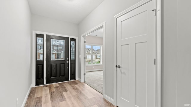 foyer featuring light hardwood / wood-style floors and a textured ceiling