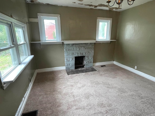 unfurnished living room with carpet flooring and a fireplace