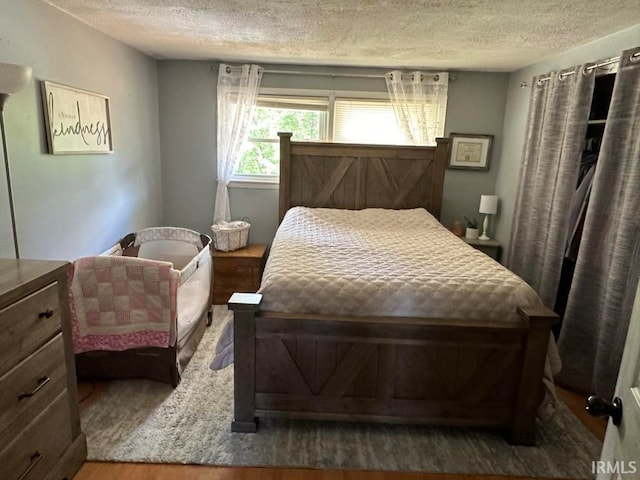 bedroom featuring hardwood / wood-style flooring and a textured ceiling