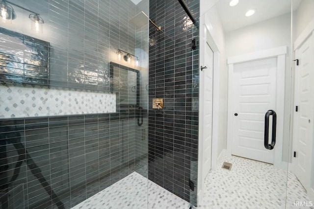 bathroom featuring a shower with door and tile patterned flooring