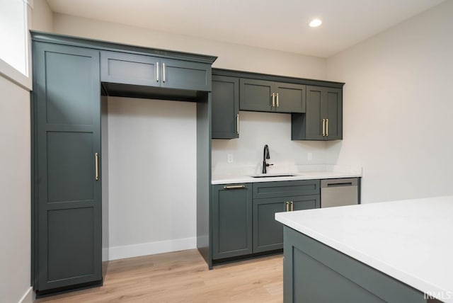 kitchen with light hardwood / wood-style flooring, stainless steel dishwasher, and sink