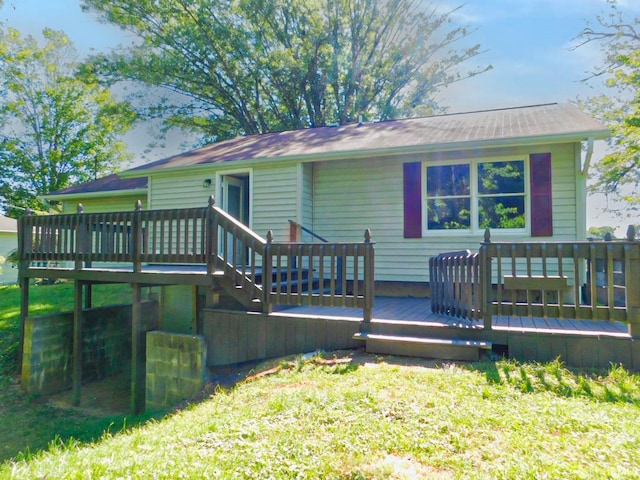 rear view of property featuring a lawn and a deck