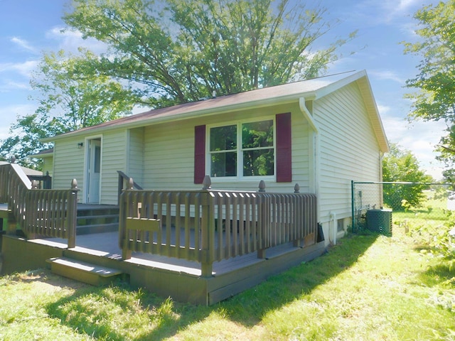 back of house featuring a lawn, cooling unit, and a deck