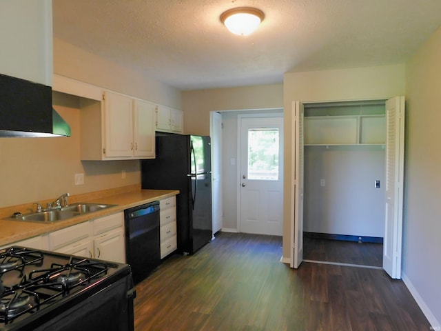 kitchen with sink, dark hardwood / wood-style floors, white cabinetry, and black appliances