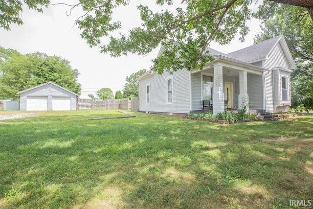 view of side of home featuring a yard, covered porch, an outdoor structure, and a garage