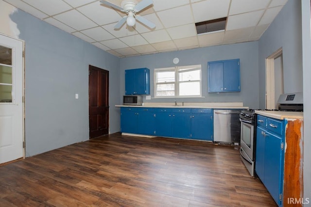 kitchen featuring a paneled ceiling, dark wood-type flooring, stainless steel appliances, and blue cabinets