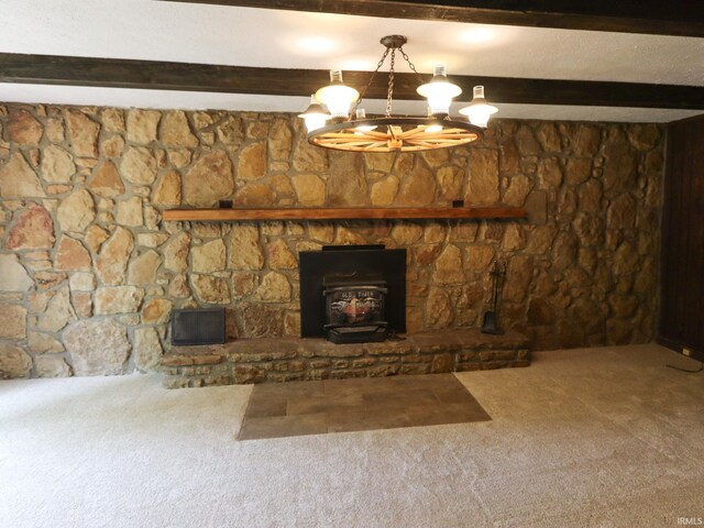 unfurnished living room with a chandelier, carpet floors, beamed ceiling, and a wood stove