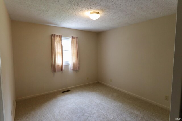 carpeted spare room with a textured ceiling