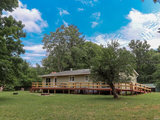 rear view of property with a wooden deck and a yard