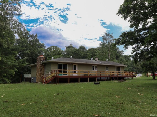 back of house featuring a lawn and a deck