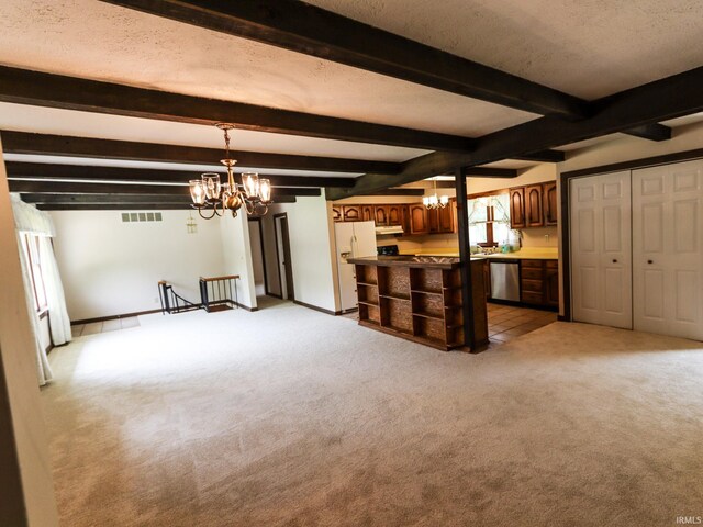 unfurnished living room featuring a healthy amount of sunlight, a chandelier, and beam ceiling