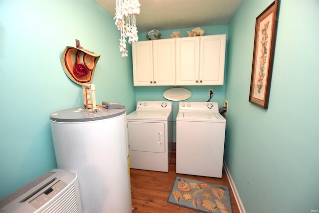 laundry area with washing machine and dryer, cabinets, light hardwood / wood-style floors, and gas water heater