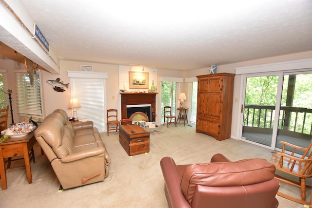 carpeted living room with a textured ceiling and a large fireplace