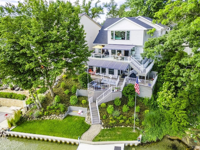 view of front of property with a shingled roof, stairway, and a front lawn