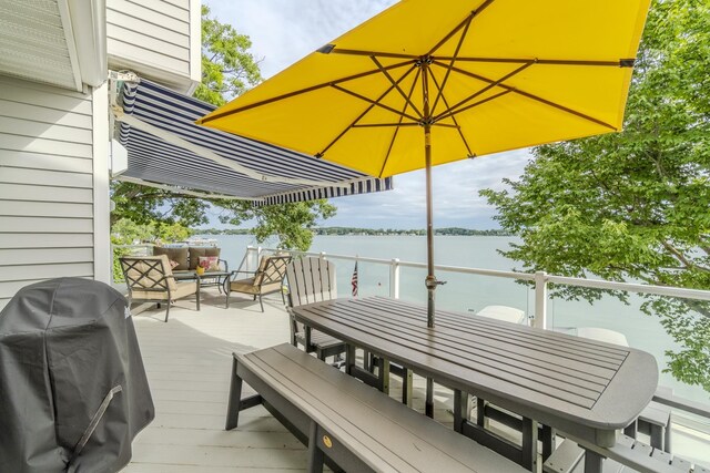 wooden deck with area for grilling and a water view