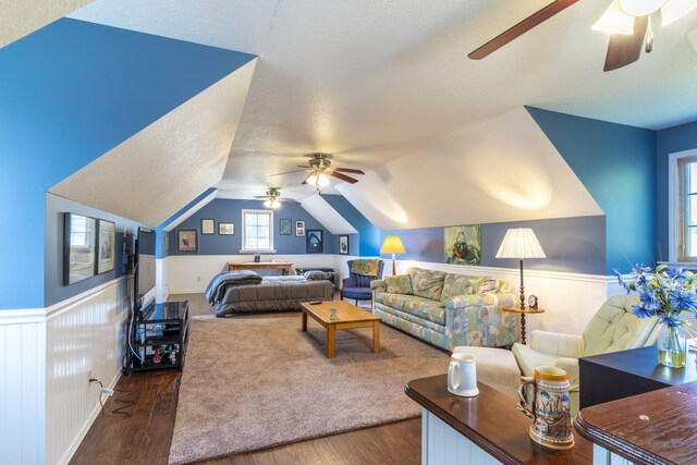 living room featuring ceiling fan, dark hardwood / wood-style flooring, and vaulted ceiling