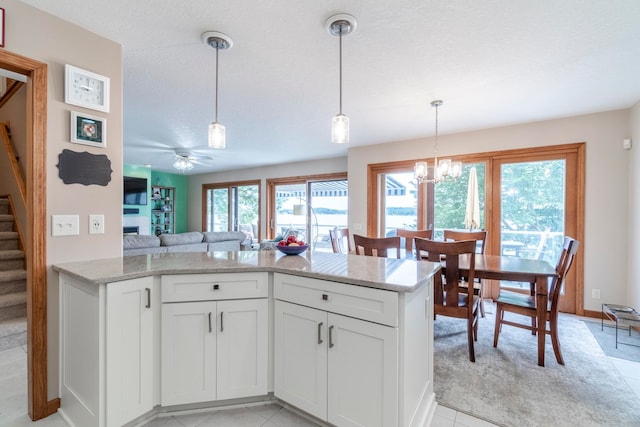 kitchen with white cabinetry, light tile patterned flooring, a healthy amount of sunlight, and pendant lighting