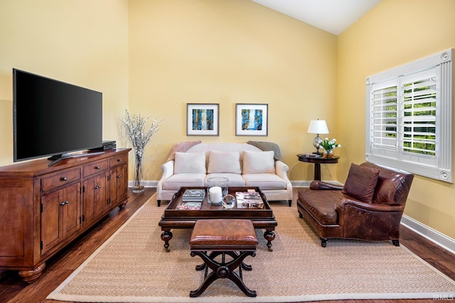 living area with dark wood-type flooring and baseboards