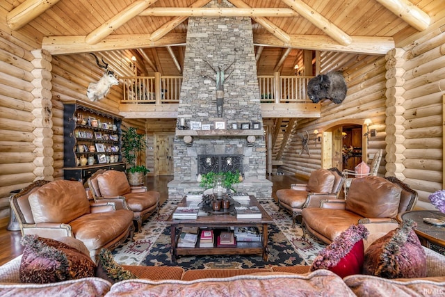 living room with wood ceiling, a stone fireplace, wood finished floors, and beam ceiling