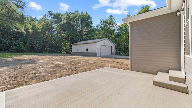 view of patio featuring an outbuilding and a garage