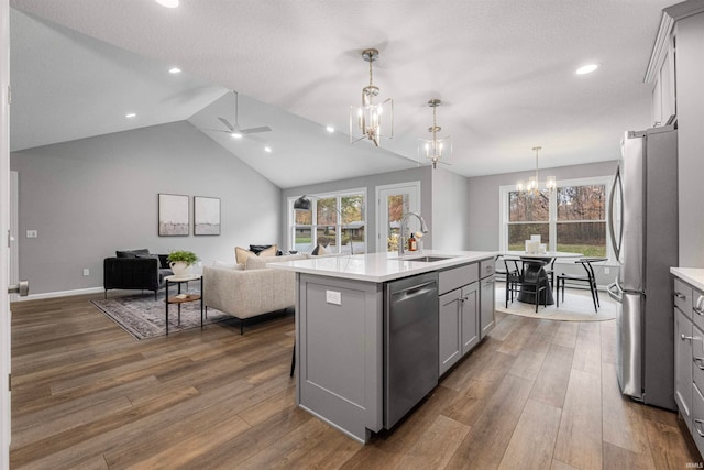 kitchen featuring stainless steel appliances, light countertops, a kitchen island with sink, and a sink