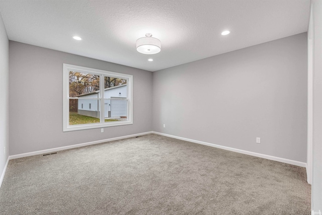 unfurnished room with carpet floors, recessed lighting, a textured ceiling, and baseboards