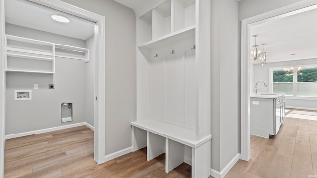 mudroom with light hardwood / wood-style flooring, sink, and a notable chandelier