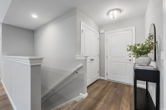 entryway with a textured ceiling, baseboards, dark wood-type flooring, and recessed lighting