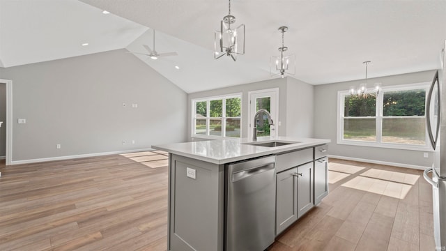 kitchen featuring appliances with stainless steel finishes, a kitchen island with sink, vaulted ceiling, light hardwood / wood-style flooring, and sink