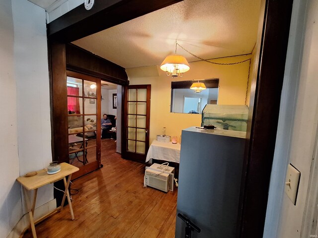 interior space with hardwood / wood-style flooring, a textured ceiling, and french doors